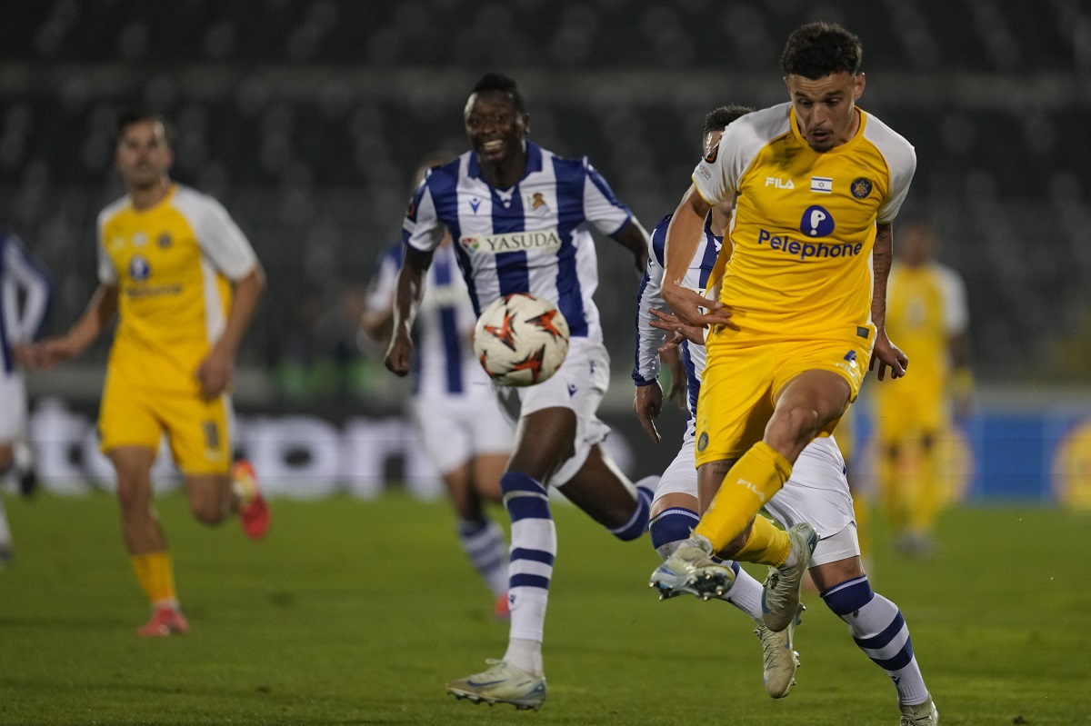 Maccabi Tel Aviv's Stav Lemkin passes the ball in front of Real Sociedad's Umar Sadiq during the Europa League opening phase soccer match between Maccabi Tel Aviv and Real Sociedad at the Partizan stadium in Belgrade, Serbia, Thursday, Oct. 24, 2024. (AP Photo/Darko Vojinovic)