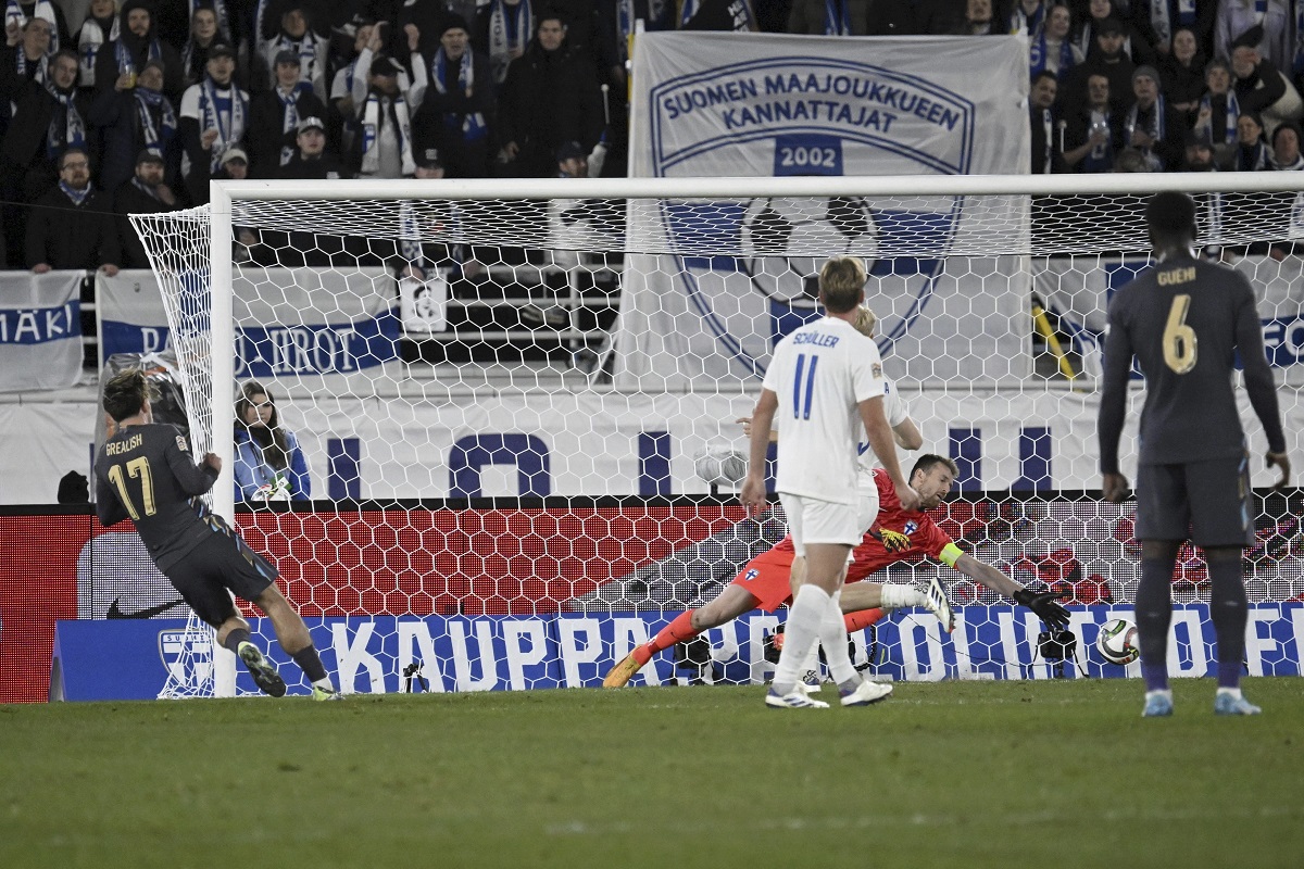 Jack Grealish of England, left, scores the opening goal past Finland's goalkeeper Lukas Hradecky during the UEFA Nations League soccer match between Finland and England, at the Olympic Stadium in Helsinki, Finland, Sunday, Oct. 13, 2024. (Markku Ulander/Lehtikuva via AP)