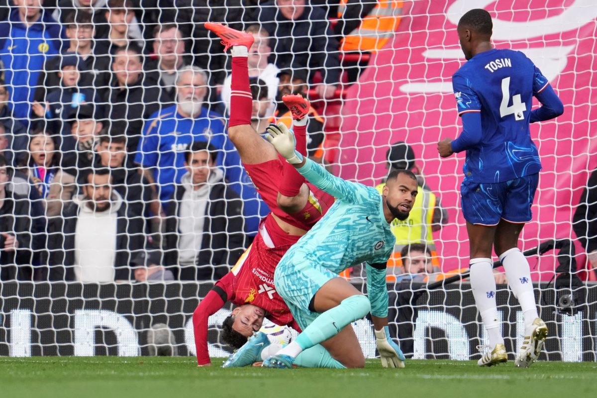 Liverpool's Curtis Jones, left, in action against Chelsea's goalkeeper Robert Sanchez during the English Premier League soccer match between Liverpool and Chelsea at Anfield Stadium, Liverpool, England, Sunday, Oct. 20, 2024. (AP Photo/Jon Super)