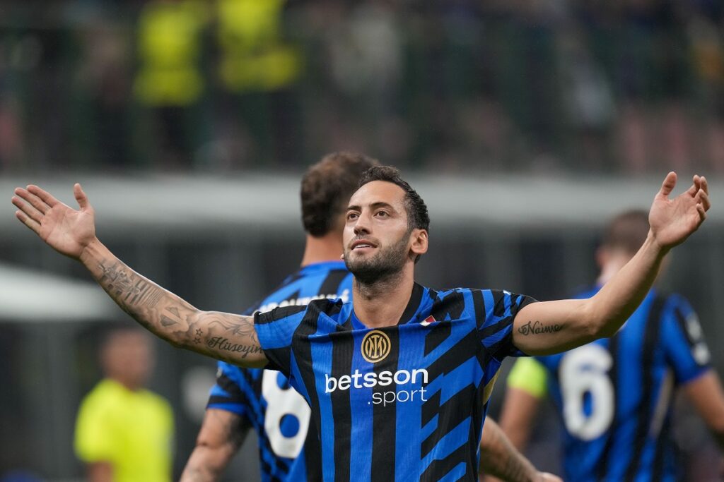 Inter Milan's Hakan Calhanoglu celebrates after scoring opening goal during the Champions League opening phase soccer match between Inter Milan and Red Star, at the San Siro stadium in Milan, Italy, Tuesday, Oct. 1, 2024. (AP Photo/Luca Bruno)