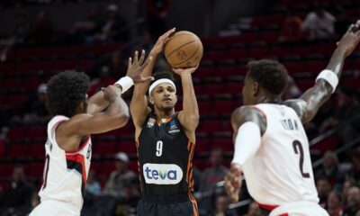 Ratiopharm Ulm guard Alfonso Plummer, center, shoots between Portland Trail Blazers guard Scoot Henderson, left, and center Deandre Ayton during the first half of a preseason NBA basketball game in Portland, Ore., Wednesday, Oct. 16, 2024. (AP Photo/Craig Mitchelldyer)