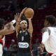 Ratiopharm Ulm guard Alfonso Plummer, center, shoots between Portland Trail Blazers guard Scoot Henderson, left, and center Deandre Ayton during the first half of a preseason NBA basketball game in Portland, Ore., Wednesday, Oct. 16, 2024. (AP Photo/Craig Mitchelldyer)