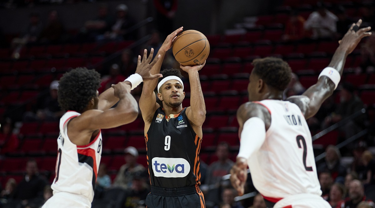 Ratiopharm Ulm guard Alfonso Plummer, center, shoots between Portland Trail Blazers guard Scoot Henderson, left, and center Deandre Ayton during the first half of a preseason NBA basketball game in Portland, Ore., Wednesday, Oct. 16, 2024. (AP Photo/Craig Mitchelldyer)