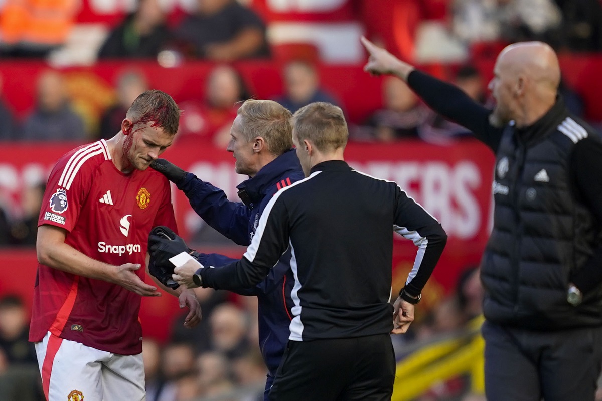 Manchester United's Matthijs de Ligt, left, receives medical treatment after sustaining an injury during the English Premier League soccer match between Manchester United and Brentford at Old Trafford stadium in Manchester, England, Saturday, Oct. 19, 2024. (AP Photo/Dave Thompson)