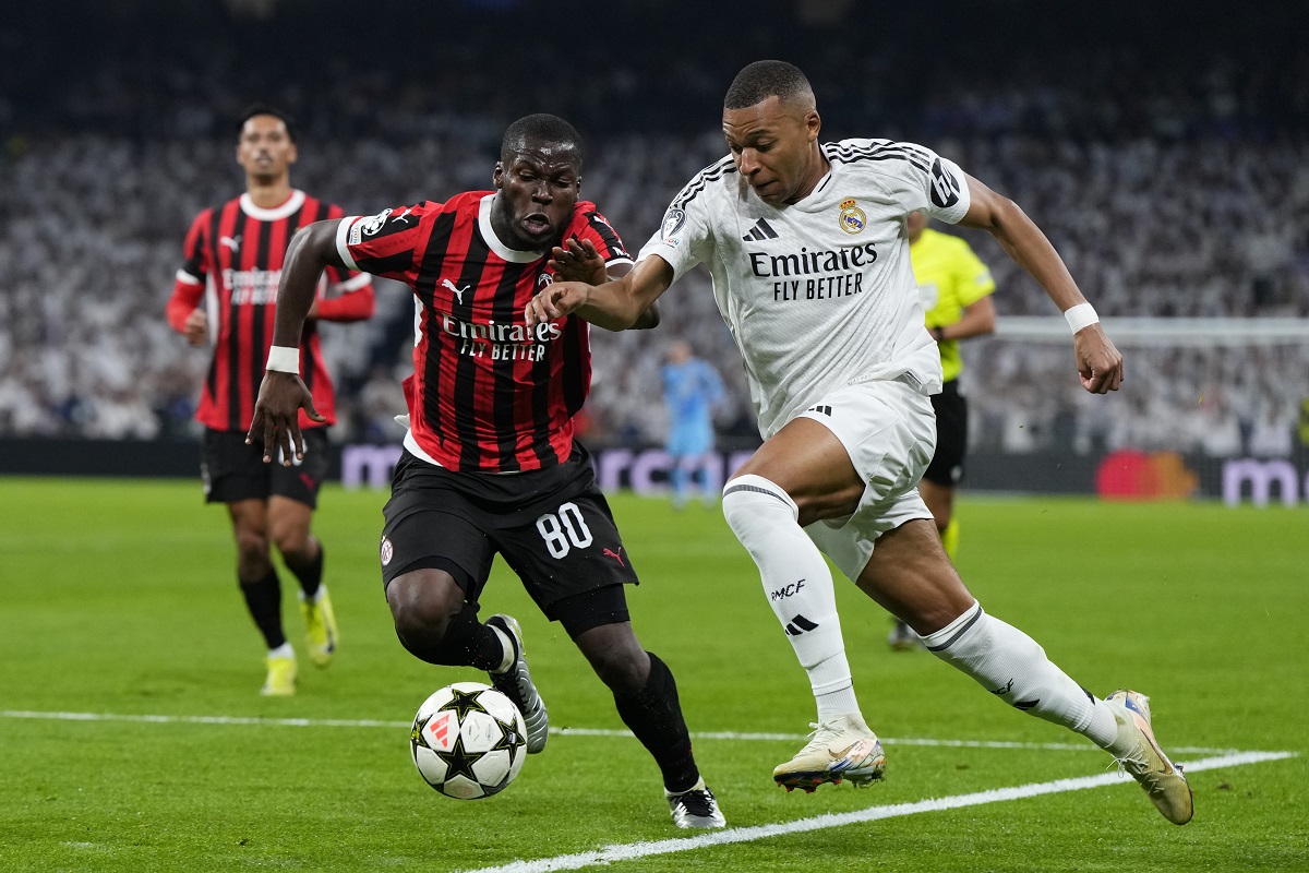 Real Madrid's Kylian Mbappe, right, and AC Milan's Yunus Musah battle for the ball during the Champions League opening phase soccer match at the Santiago Bernabeu stadium in Madrid, Spain, Tuesday, Nov. 5, 2024. (AP Photo/Manu Fernandez)