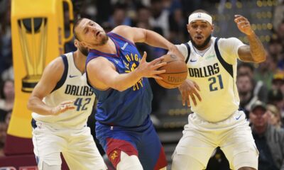 Denver Nuggets center Nikola Jokic, center, bobbles the ball against Dallas Mavericks center Daniel Gafford (21) during the first half of an Emirates NBA Cup basketball game Friday, Nov. 22, 2024, in Denver. (AP Photo/Jack Dempsey)