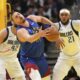 Denver Nuggets center Nikola Jokic, center, bobbles the ball against Dallas Mavericks center Daniel Gafford (21) during the first half of an Emirates NBA Cup basketball game Friday, Nov. 22, 2024, in Denver. (AP Photo/Jack Dempsey)