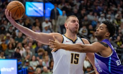 Denver Nuggets center Nikola Jokic (15) controls the ball as Utah Jazz forward Brice Sensabaugh (28) defends during the second half of an NBA basketball game Wednesday, Nov. 27, 2024, in Salt Lake City. (AP Photo/Rick Egan)