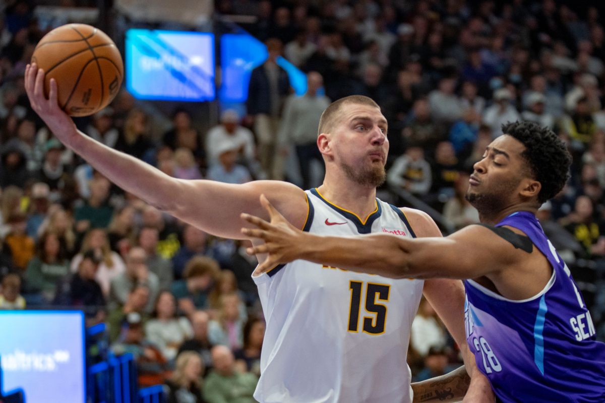 Denver Nuggets center Nikola Jokic (15) controls the ball as Utah Jazz forward Brice Sensabaugh (28) defends during the second half of an NBA basketball game Wednesday, Nov. 27, 2024, in Salt Lake City. (AP Photo/Rick Egan)