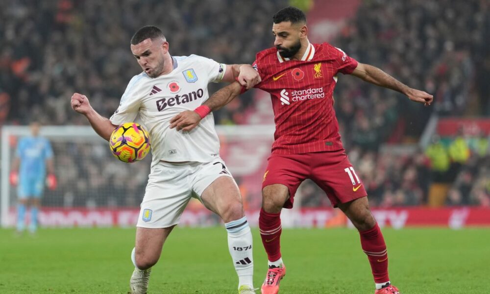 Aston Villa's John McGinn, left, and Liverpool's Mohamed Salah battle for the ball during the English Premier League soccer match at the Anfield stadium in Liverpool, Saturday, Nov. 9, 2024. (AP Photo/Jon Super)