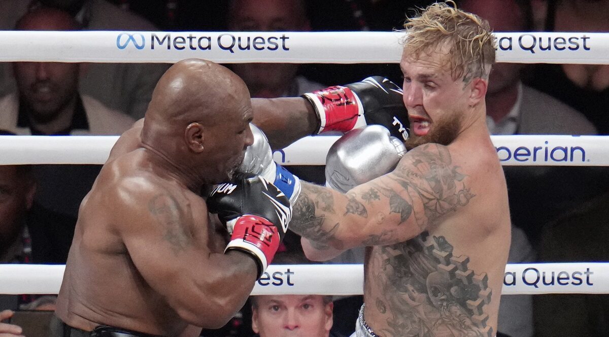 Mike Tyson hits Jake Paul during their heavyweight boxing match, Friday, Nov. 15, 2024, in Arlington, Texas. (AP Photo/Julio Cortez)