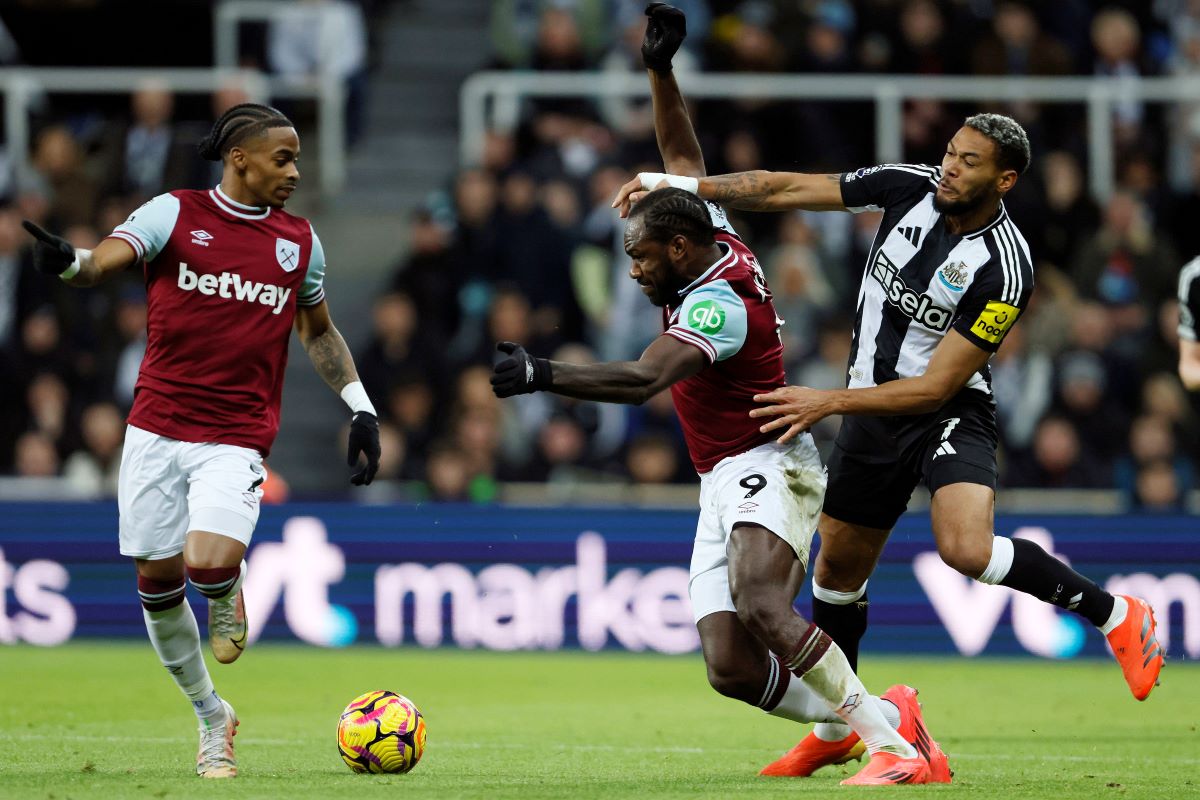 West Ham United's Michail Antonio, center, and Newcastle United's Joelinton, right, challenge for the ball during the English Premier League soccer match between Newcastle United and West Ham United in Newcastle, England, Monday, Nov. 25, 2024. (Richard Sellers/PA via AP)