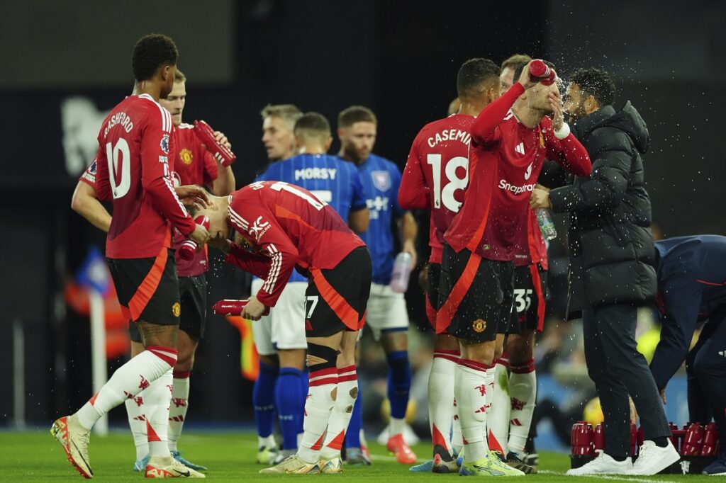 Manchester United's Diogo Dalot splashes his face with water during the English Premier League soccer match between Ipswich Town and Manchester United at Portman Road stadium in Ipswich, England, Sunday, Nov. 24, 2024. (AP Photo/Dave Shopland)