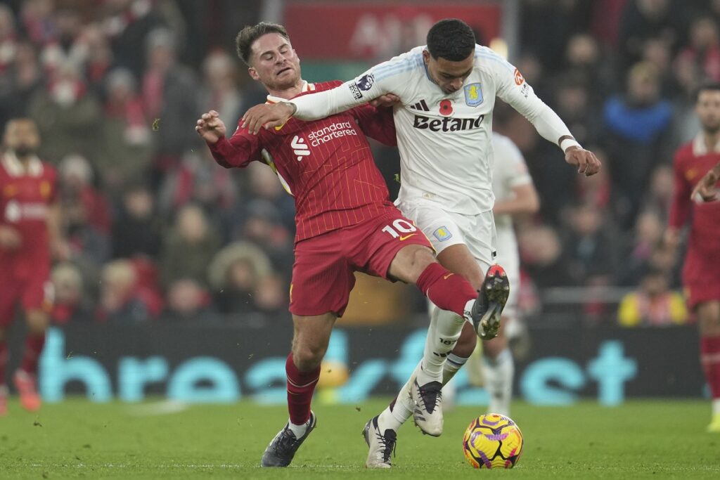 Aston Villa's Morgan Rogers, right, and Liverpool's Alexis Mac Allister battle for the ball during the English Premier League soccer match at the Anfield stadium in Liverpool, Saturday, Nov. 9, 2024. (AP Photo/Jon Super)