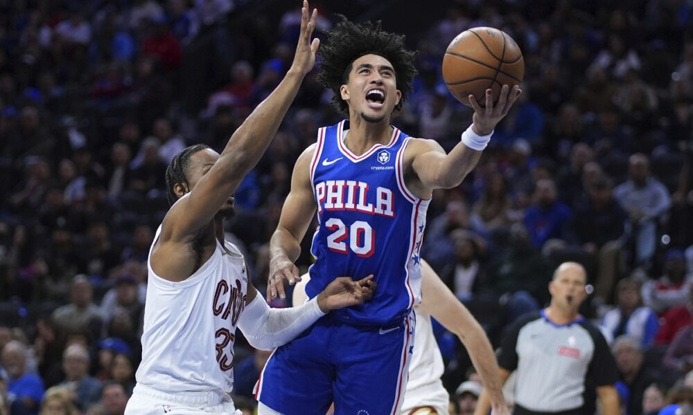 Philadelphia 76ers' Jared McCain, right, goes up for a shot against Cleveland Cavaliers' Isaac Okoro during the first half of an NBA basketball game, Wednesday, Nov. 13, 2024, in Philadelphia. (AP Photo/Matt Slocum)