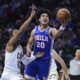 Philadelphia 76ers' Jared McCain, right, goes up for a shot against Cleveland Cavaliers' Isaac Okoro during the first half of an NBA basketball game, Wednesday, Nov. 13, 2024, in Philadelphia. (AP Photo/Matt Slocum)