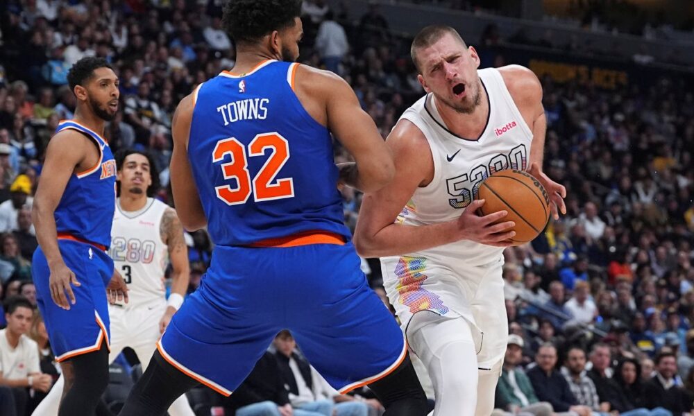 Denver Nuggets center Nikola Jokic, right, drives past New York Knicks center Karl-Anthony Towns (32) in the second half of an NBA basketball game Monday, Nov. 25, 2024, in Denver. (AP Photo/David Zalubowski)