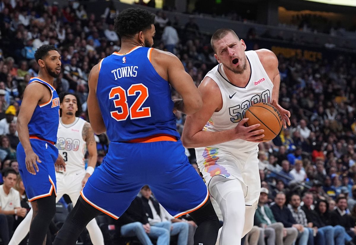 Denver Nuggets center Nikola Jokic, right, drives past New York Knicks center Karl-Anthony Towns (32) in the second half of an NBA basketball game Monday, Nov. 25, 2024, in Denver. (AP Photo/David Zalubowski)