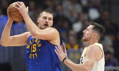 Denver Nuggets center Nikola Jokic, left, looks to pass the ball as Utah Jazz forward Drew Eubanks defends in the second half of an NBA basketball game Saturday, Nov. 2, 2024, in Denver. (AP Photo/David Zalubowski)