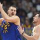 Denver Nuggets center Nikola Jokic, left, looks to pass the ball as Utah Jazz forward Drew Eubanks defends in the second half of an NBA basketball game Saturday, Nov. 2, 2024, in Denver. (AP Photo/David Zalubowski)