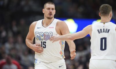 Denver Nuggets center Nikola Jokic, left, is congratulated after hitting a 3-point basket by guard Christian Braun in the second half of an NBA basketball game against the Phoenix Suns Monday, Dec. 23, 2024, in Denver. (AP Photo/David Zalubowski)