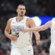 Denver Nuggets center Nikola Jokic, left, is congratulated after hitting a 3-point basket by guard Christian Braun in the second half of an NBA basketball game against the Phoenix Suns Monday, Dec. 23, 2024, in Denver. (AP Photo/David Zalubowski)