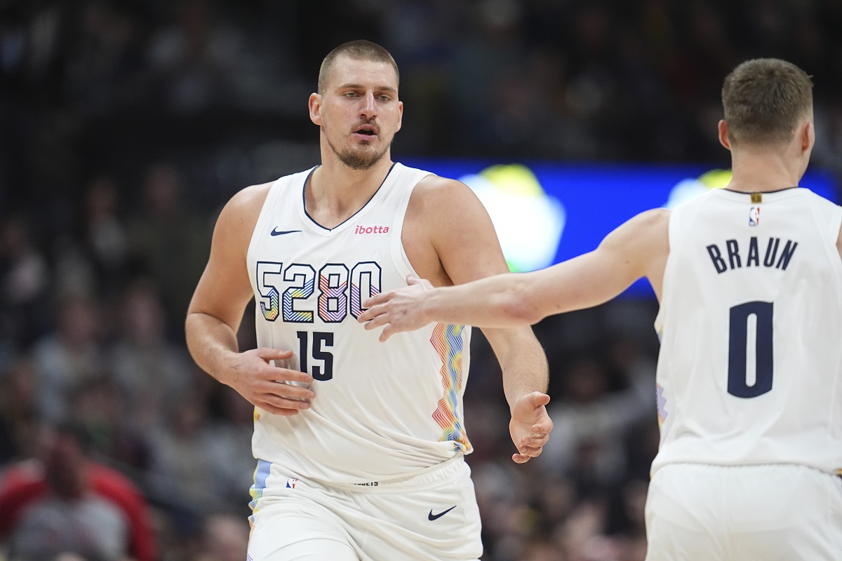 Denver Nuggets center Nikola Jokic, left, is congratulated after hitting a 3-point basket by guard Christian Braun in the second half of an NBA basketball game against the Phoenix Suns Monday, Dec. 23, 2024, in Denver. (AP Photo/David Zalubowski)