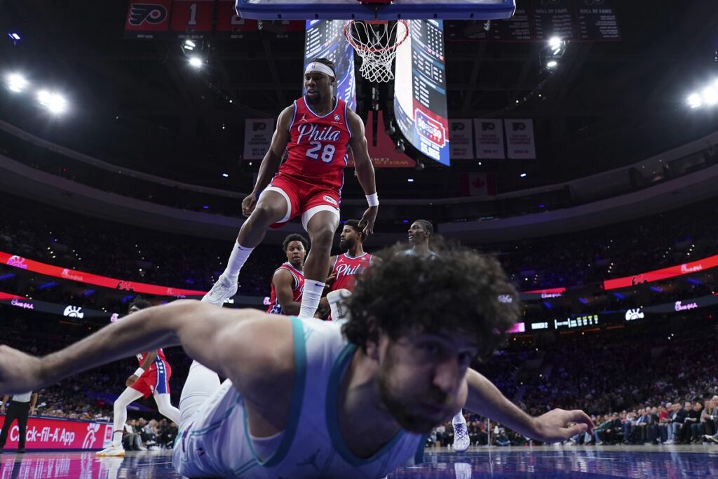 Charlotte Hornets' Vasilije Micic, bottom, slides after colliding with Philadelphia 76ers' Guerschon Yabusele, top, during the second half of an NBA basketball game, Friday, Dec. 20, 2024, in Philadelphia. (AP Photo/Matt Slocum)