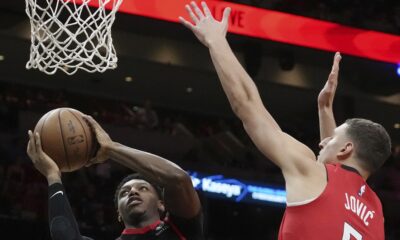 Toronto Raptors guard RJ Barrett (9) drives to the basket as Miami Heat forward Nikola Jovic (5) defends during the second half of an NBA basketball game, Thursday, Dec. 12, 2024, in Miami. (AP Photo/Marta Lavandier)