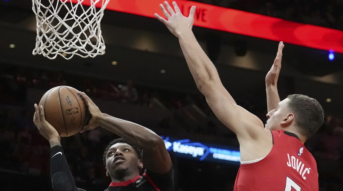 Toronto Raptors guard RJ Barrett (9) drives to the basket as Miami Heat forward Nikola Jovic (5) defends during the second half of an NBA basketball game, Thursday, Dec. 12, 2024, in Miami. (AP Photo/Marta Lavandier)