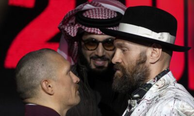 Boxer Tyson Fury, right, and Oleksandr Usyk, left, face off under the eyes of Turki Al-Sheik during a press conference in Riyadh, Saudi Arabia, Thursday, Dec. 19, 2024 ahead of the WBA, WBO, and WBC heavyweight title bout between Britain's Tyson Fury and Ukraine's Oleksandr Usyk. (AP Photo/Frank Augstein)