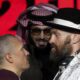 Boxer Tyson Fury, right, and Oleksandr Usyk, left, face off under the eyes of Turki Al-Sheik during a press conference in Riyadh, Saudi Arabia, Thursday, Dec. 19, 2024 ahead of the WBA, WBO, and WBC heavyweight title bout between Britain's Tyson Fury and Ukraine's Oleksandr Usyk. (AP Photo/Frank Augstein)