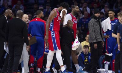 Philadelphia 76ers' Joel Embiid, center, gets helped off the court after getting hit in the face during the first half of an NBA basketball game against the Indiana Pacers, Friday, Dec. 13, 2024, in Philadelphia. (AP Photo/Chris Szagola)