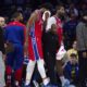 Philadelphia 76ers' Joel Embiid, center, gets helped off the court after getting hit in the face during the first half of an NBA basketball game against the Indiana Pacers, Friday, Dec. 13, 2024, in Philadelphia. (AP Photo/Chris Szagola)