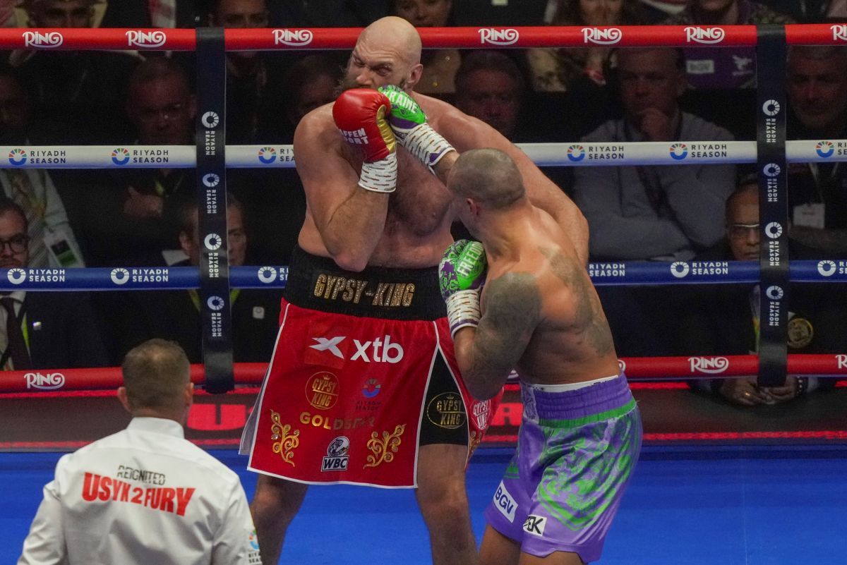 Boxers Britain's Tyson Fury, left, and Ukraine's Oleksandr Usyk compete during their WBA, WBO, and WBC world heavyweight title fight in Riyadh, Saudi Arabia, Saturday, Dec. 21, 2024. (AP Photo/Frank Augstein)