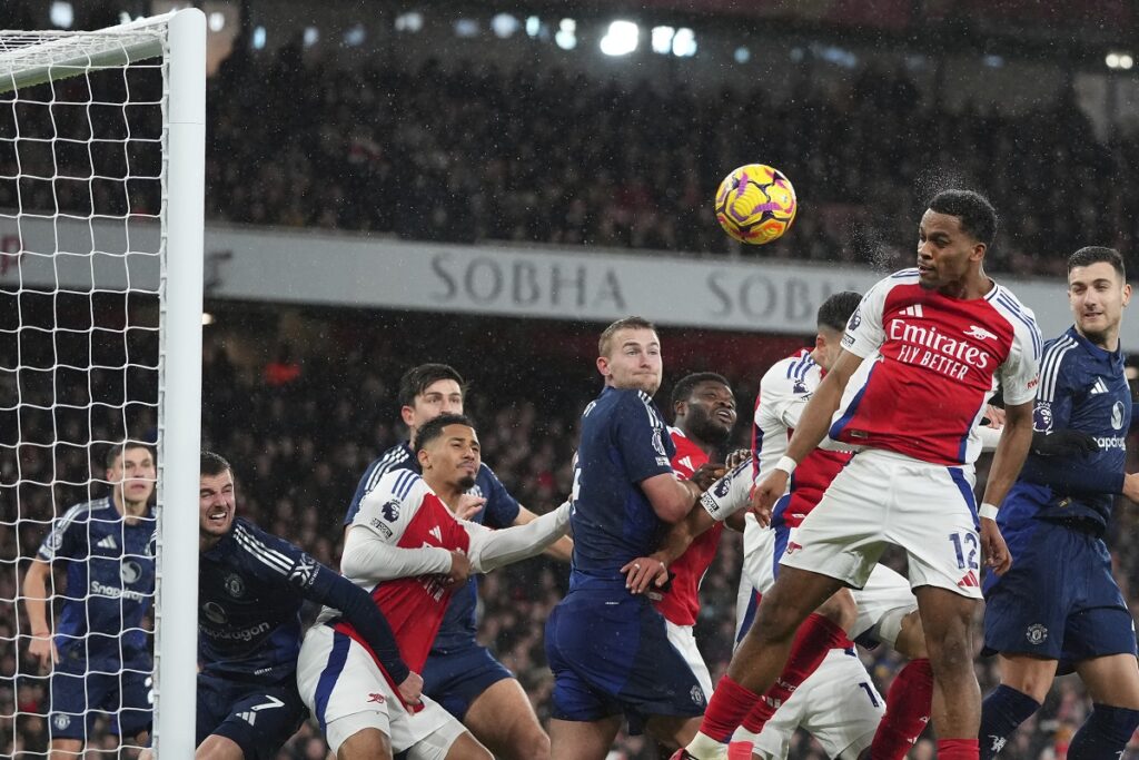 Arsenal's Jurrien Timber, right, heads the ball to score his side's first goal during the English Premier League soccer match between Arsenal and Manchester United at Emirates stadium in London, Wednesday, Dec. 4, 2024. (AP Photo/Kirsty Wigglesworth)