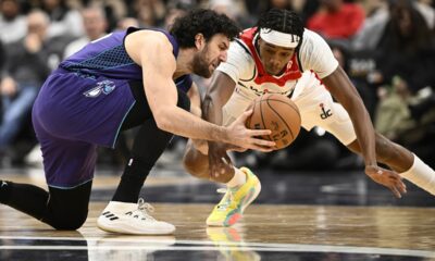 Charlotte Hornets guard Vasilije Micic, left, and Washington Wizards guard Bilal Coulibaly, right, battle for the ball during the first half of an NBA basketball game, Thursday, Dec. 19, 2024, in Washington. (AP Photo/Nick Wass)