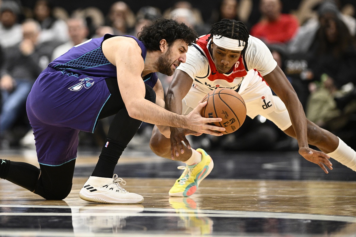 Charlotte Hornets guard Vasilije Micic, left, and Washington Wizards guard Bilal Coulibaly, right, battle for the ball during the first half of an NBA basketball game, Thursday, Dec. 19, 2024, in Washington. (AP Photo/Nick Wass)