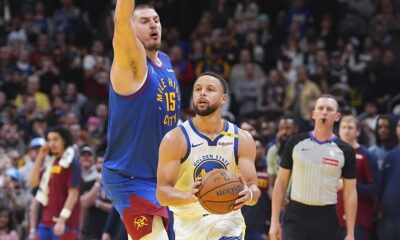 Golden State Warriors guard Stephen Curry, right, drives past Denver Nuggets center Nikola Jokic to put up a last-second, 3-point shot in the second half of an Emirates NBA Cup basketball game Tuesday, Dec. 3, 2024, in Denver. (AP Photo/David Zalubowski)