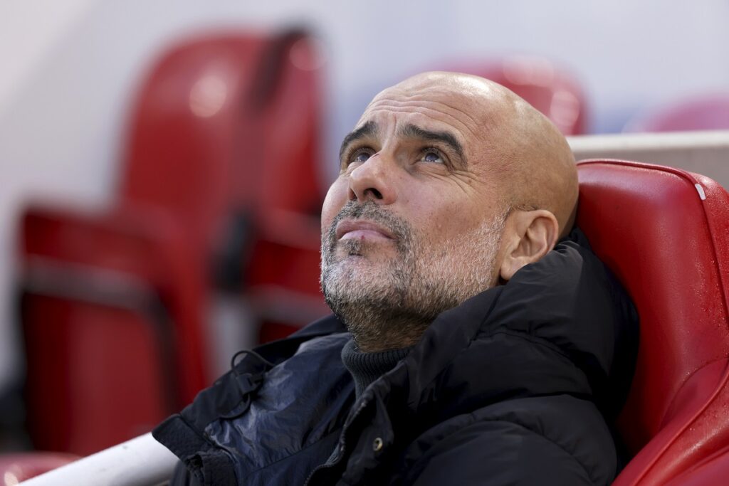 Manchester City's head coach Pep Guardiola sits on the bench before the English Premier League soccer match between Liverpool and Manchester City at Anfield Stadium, Liverpool, England, Sunday Dec. 1, 2024. (AP Photo/Ian Hodgson)