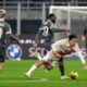 AC Milan's Youssouf Fofana, center left, and Roma's Paulo Dybala fights for the ball during the Serie A soccer match between AC Milan and Roma at the San Siro stadium, in Milan, Italy, Sunday, Dec. 29, 2024. (AP Photo/Antonio Calanni)