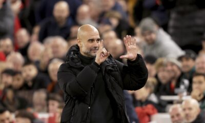 Manchester City's head coach Pep Guardiola puts up six fingers to remind the jeering fans of his six Premier League titles at the end of the English Premier League soccer match between Liverpool and Manchester City at Anfield Stadium, Liverpool, England, Sunday Dec. 1, 2024. (AP Photo/Ian Hodgson)