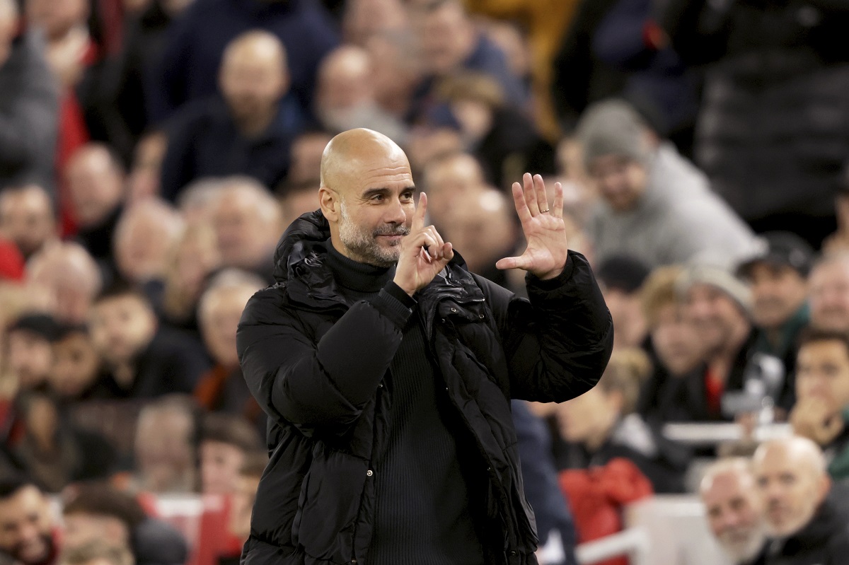 Manchester City's head coach Pep Guardiola puts up six fingers to remind the jeering fans of his six Premier League titles at the end of the English Premier League soccer match between Liverpool and Manchester City at Anfield Stadium, Liverpool, England, Sunday Dec. 1, 2024. (AP Photo/Ian Hodgson)