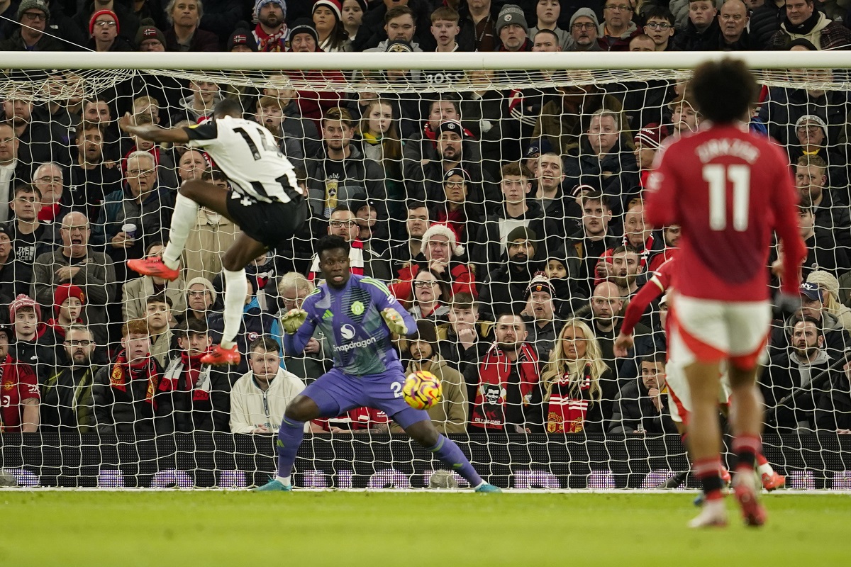 Newcastle's Alexander Isak, left, scores his side's opening goal during the English Premier League soccer match between Manchester United and Newcastle at the Old Trafford stadium in Manchester, England, Monday, Dec. 30, 2024. (AP Photo/Dave Thompson)