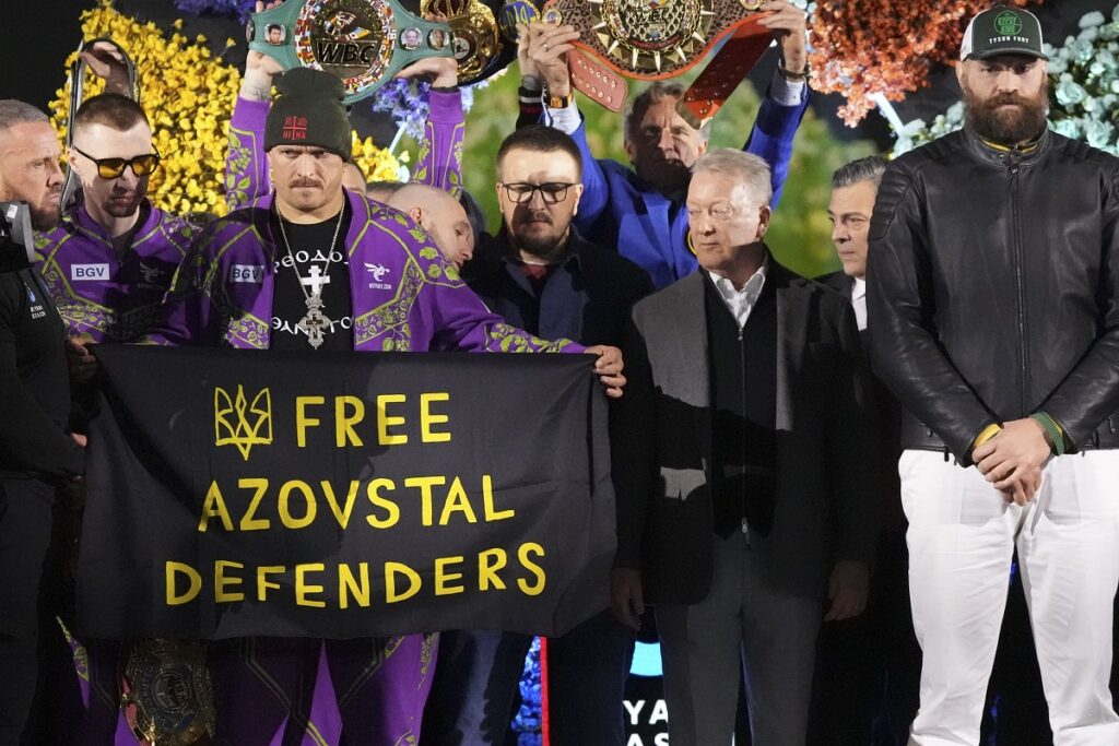 Boxers Britain's Tyson Fury, right, and world champion Ukraine's Oleksandr Usyk, third left, stand on stage during the weigh-in for their WBA, WBO, and WBC heavyweight title bout in Riyadh, Saudi Arabia, Friday, Dec. 20, 2024. (AP Photo/Frank Augstein)