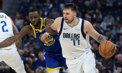 Golden State Warriors forward Andrew Wiggins (22) defends against Dallas Mavericks forward Luka Dončić (77) during the first half of an NBA basketball game Sunday, Dec. 15, 2024, in San Francisco. (AP Photo/Benjamin Fanjoy)