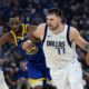 Golden State Warriors forward Andrew Wiggins (22) defends against Dallas Mavericks forward Luka Dončić (77) during the first half of an NBA basketball game Sunday, Dec. 15, 2024, in San Francisco. (AP Photo/Benjamin Fanjoy)