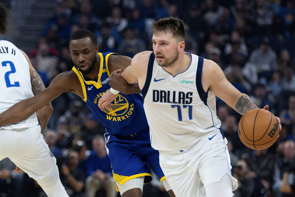 Golden State Warriors forward Andrew Wiggins (22) defends against Dallas Mavericks forward Luka Dončić (77) during the first half of an NBA basketball game Sunday, Dec. 15, 2024, in San Francisco. (AP Photo/Benjamin Fanjoy)