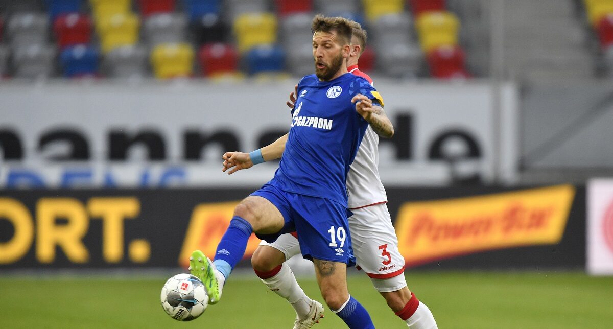 FILE - Schalke's Guido Burgstaller, left, is challenged by Duesseldorf's Andre Hoffman during the German Bundesliga soccer match between Fortuna Duesseldorf and FC Schalke 04 in Duesseldorf, Germany, on May 27, 2020. (AP Photo/Martin Meissner, Pool, File)