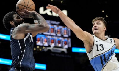 Dallas Mavericks guard Kyrie Irving (11) shoots against Atlanta Hawks guard Bogdan Bogdanovic (13) during the second half of an NBA basketball game, Monday, Nov. 25, 2024, in Atlanta. (AP Photo/Mike Stewart)